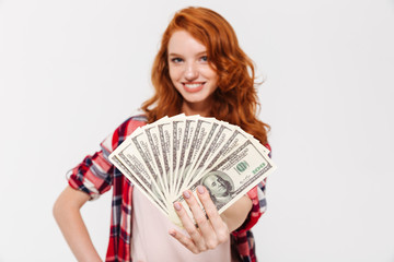 Sticker - Cheerful pretty young redhead lady holding money.