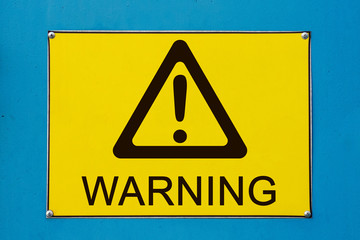 Closeup view of street warning exclamation sign on yellow metallic board