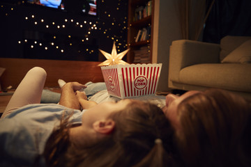 Father And Daughter Enjoying Movie Night At Home Together