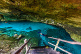 Fototapeta Łazienka - Cenote Dos Ojos in Quintana Roo, Mexico. People swimming and snorkeling in clear blue water. This cenote is located close to Tulum in Yucatan peninsula, Mexico.