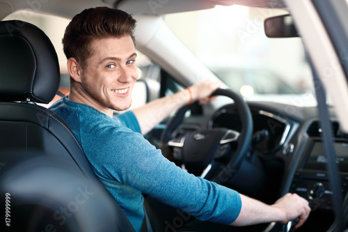 Fotomural Happy young male driver behind the wheel
