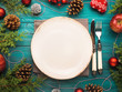 © tenkende - Christmas dark green background with empty dish and cutlery. Festive holiday dinner concept