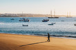 Tourist walking on the beach in Cascais, Portugal at sunrise