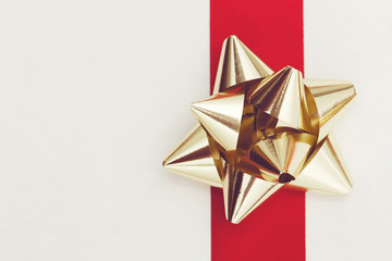 Wall Mural - Metallic gift bow on a red background