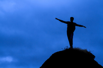 Wall Mural - Man standing on the top of a mountain.