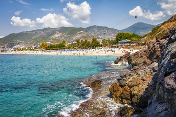 Wall Mural - Rocky seascape of Alanya beach in Turkey on sunny summer day. Landscape of mountains and costline of blue sea. Scenery paradise lagoon bay on tropical beach