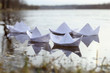 © vaitekune - Origami paper ships sailing in river. Paper boats made from mathematics notebook paper.