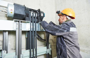 lift machinist repairing elevator in lift shaft