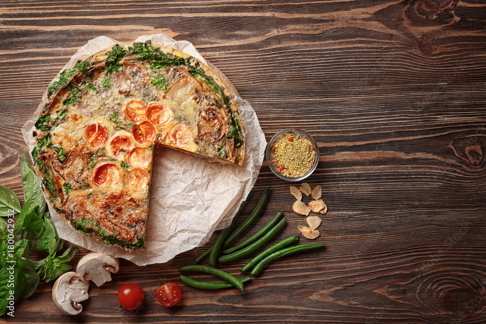 Delicious spinach frittata on wooden background