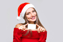 Closeup Of A Smiling Beautiful Woman In Santa Hat And Red Dress Holding White Card In Her Hands