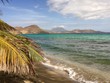 Tropical beach with palm trees, mountains and beautiful reef at St Kitts