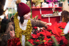 Teenager Girl Buying Floral  Composition At Christmas Fair
