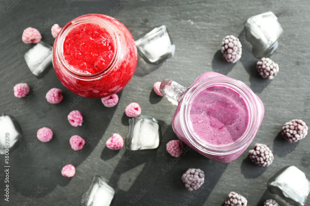 Glassware with different smoothies on grey background