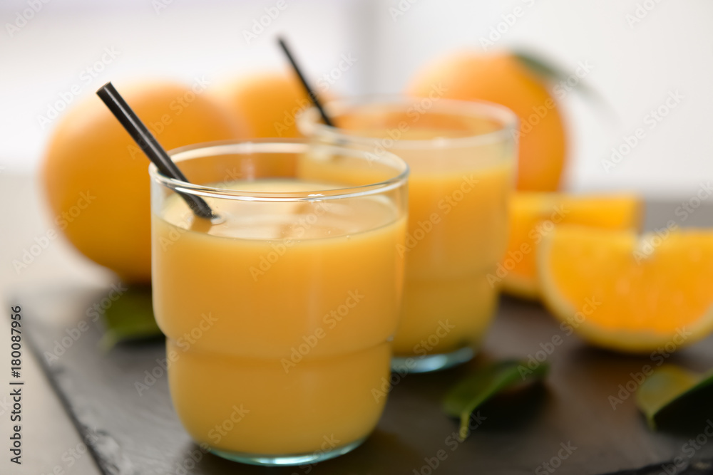 Glasses of fresh orange juice on slate plate