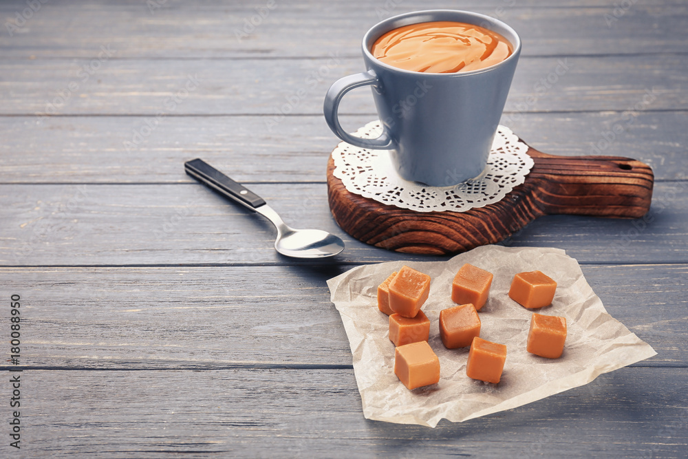 Composition with tasty caramel candies on wooden background