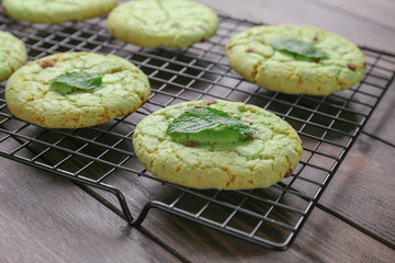 Wall Mural - Baking grid with mint chocolate chip cookies on wooden table, closeup