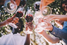 Group Of Friends Toasting With Wine Glasses At Party