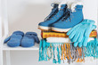 winter shoes, gloves and scarf on white wooden shelf
