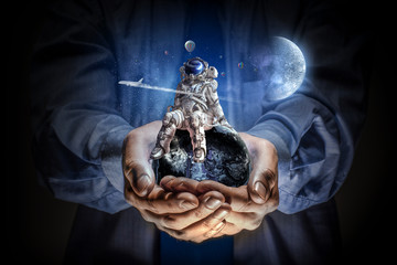 Wall Mural - spaceman in male hand. mixed media