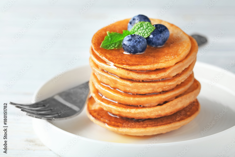 Plate with tasty buckwheat pancakes on table, closeup