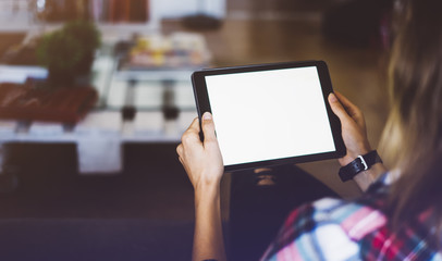 Wall Mural - Hipster girl using tablet technology in home atmosphere, girl person holding computer with blank screen on background bokeh, female hands texting on relax holiday, mockup templates 