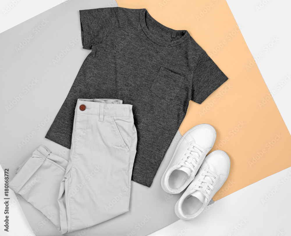 Set of child's clothes on color background