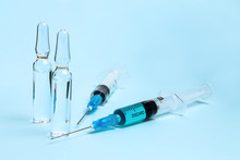 Two Syringes And Two Ampoules With Drug On Blue Background
