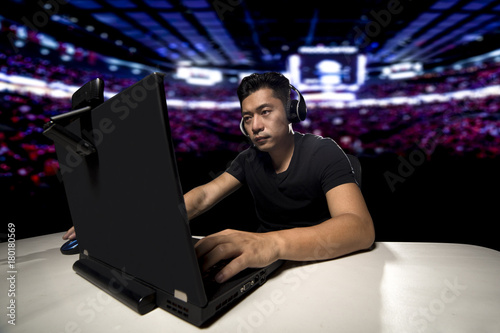 Foto Competitive asian male professional E Sports video gamer playing an FPS, or MMO game on a computer and streaming online