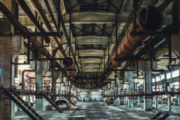 Abandoned Industrial workshop or hall of production for heavy industry factory . Huge steel pipes inside plant