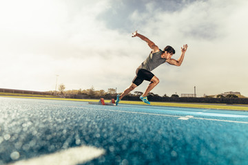 Wall Mural - sprinter taking off from starting block on running track