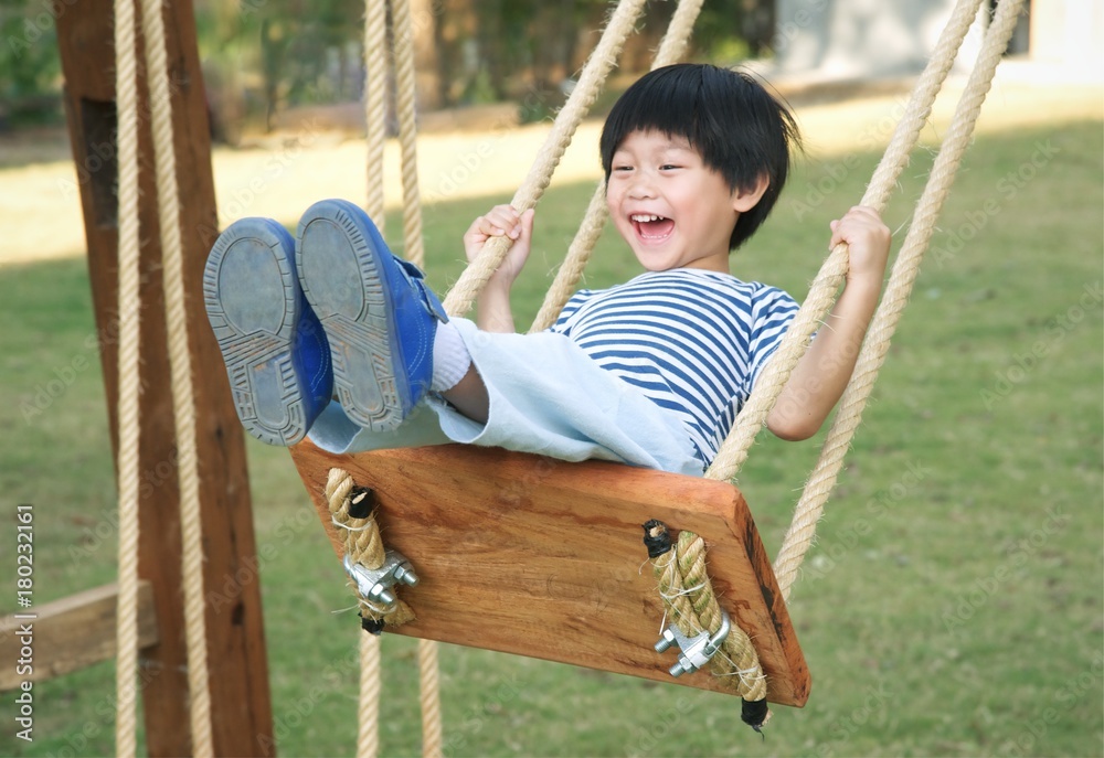 Happy Little Asia Boy Laughing And Swinging On A Swing Foto