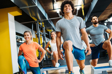 Wall Mural - Group of young people doing exercises in gym