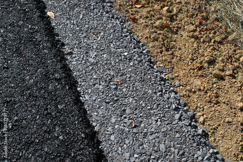 Fotografie, Obraz Background of layers of a new roadway with asphalt, gravel, and dirt, horizontal