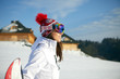 © ZoomTeam - Sporty female holds snowboard in mountains