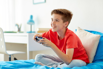 Wall Mural - happy boy with gamepad playing video game at home