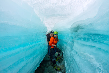 Wall Mural - Female and man inside the crack in the ice glaciers Iceland.