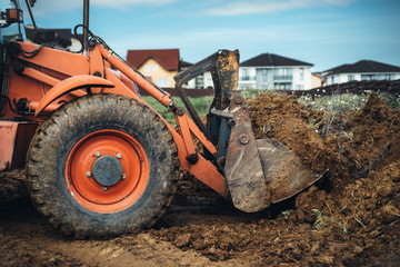 Wall Mural - Industrial machinery at working construction site. Backhoe loader working with engineer