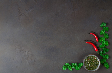 Wall Mural - Argentinian chimichurri sauce in a small gray bowl on a dark sla