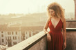 © patronestaff - Beautiful woman wearing red dress and being pensive, cityscape
