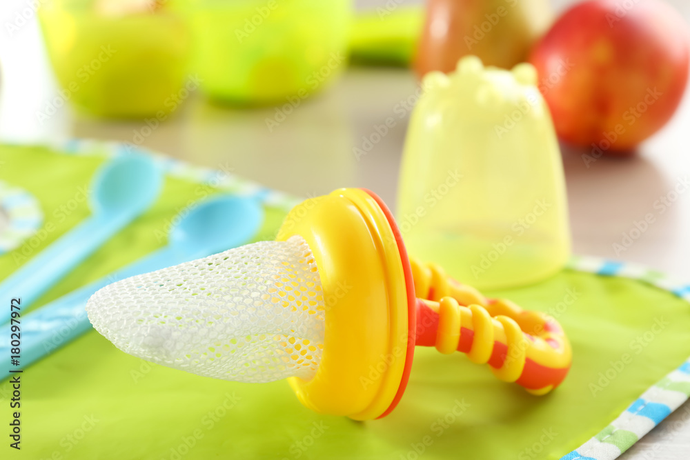 Baby's nibbler and bib on table