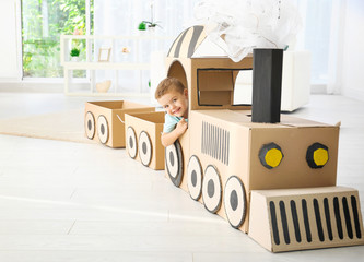 Canvas Print - Little boy playing with cardboard train in light room