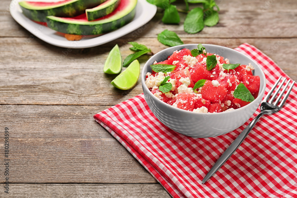 Bowl with delicious watermelon salad on wooden table