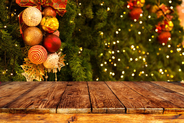 christmas tree background with decoration and blurred light bokeh with empty dark wooden deck table 
