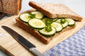 Wall Mural - preparing a brown toast sandwich with organic cucumber