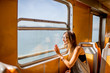 Young woman traveling in the old ferry enjoying view on the sea from the window