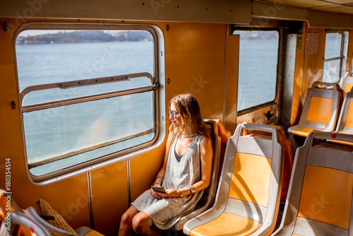 Fotomural Young woman traveling in the old ferry enjoying view on the sea from the window