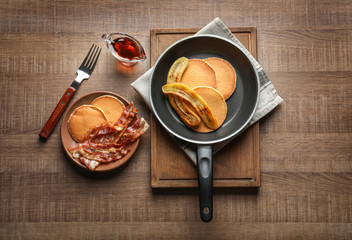 Wall Mural - Tasty pancakes with bacon and banana on table