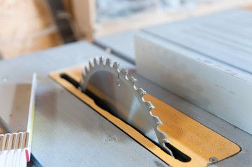 Wall Mural - Table saw blade close up shot in a small workshop.