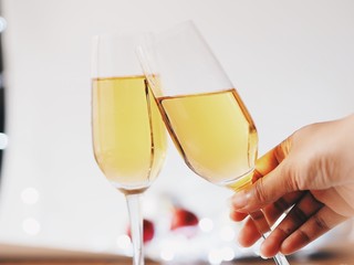 A glass of champagne with blurry Christmas decoration background.