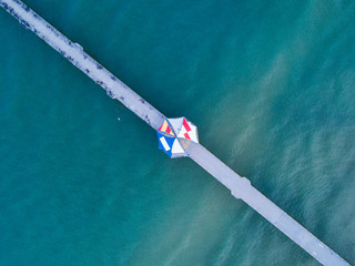 Aerial view of colorful umbrella in the middle of pier.